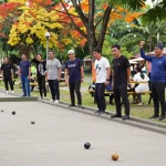 FOPI Kota Palopo community enjoying petanque at a vibrant park, showcasing diversity and excitement.